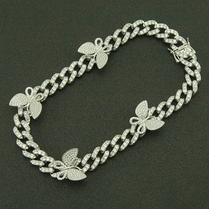 Détail de la chaîne cubaine argentée avec pendentifs papillon givrés et fermoir à cliquet
