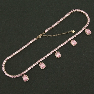 Detail of gold tennis necklace featuring pink round zircons and rectangular pendants