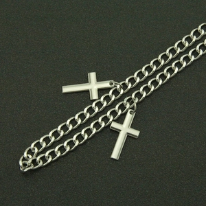 Close-up of hip-hop silver metal wallet chain featuring dual cross pendants and cuban links