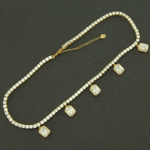 Gold-plated tennis necklace with dangling rectangular zircon stones and a heart charm
