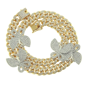 Detailopname van de iced out cubaanse ketting met zilveren vlinderhangers en diamant