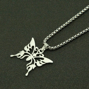 Détail du pendentif papillon évidé avec motifs de flammes sur chaîne en acier