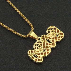 Gros plan du pendentif 888 doré avec motif de treillis ajouré et chaîne à billes classique