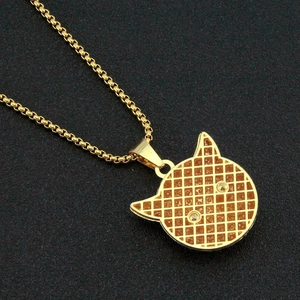 Detailed back view of gold-tone monster pendant with intricate textured grid and box chain