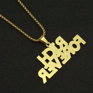 Detailed view of golden box chain and embossed FOREVER letter pendant on black background