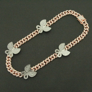 Detail van roségouden Cubaanse schakelketting met vier ijskoude vlinderhangers