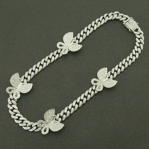 Detailopname van de iced-out Cubaanse ketting met sprankelende vlinders en pavé diamanten