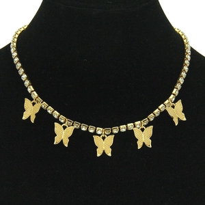 Détail du collier choker doré avec cinq papillons sertis de cristaux sur présentoir