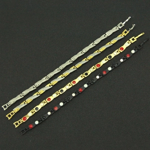 Détail de quatre bracelets à maillons métalliques en finitions argent, or et noir