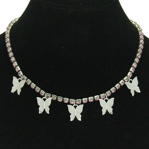 Collier Y2K argenté avec cinq papillons en strass rose présentés sur un buste noir
