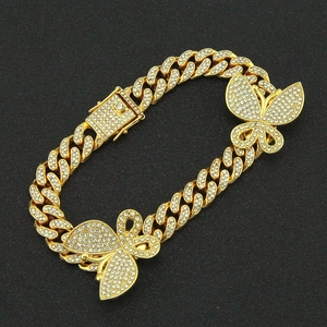 Detail van gouden Cubaanse schakelarmband met ijzige vlinderbedeltjes en fonkelende baksluiting