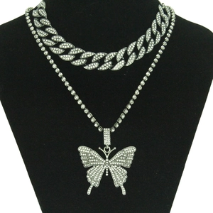 Détail du collier à maillons cubains argentés et chaîne tennis avec grand pendentif papillon