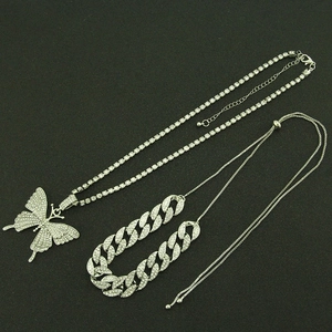 Vue détaillée du collier pendentif papillon argenté et du bracelet cubain serti de diamants