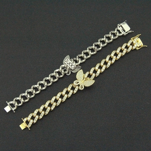 Close-up of gold and silver butterfly Cuban link bracelets with cubic zirconia stones