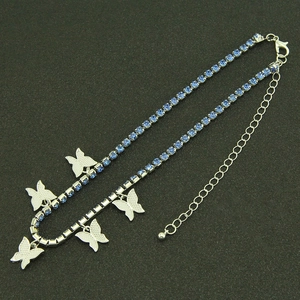 Détails des pendentifs papillons argentés et de la chaîne en strass bleus avec fermoir
