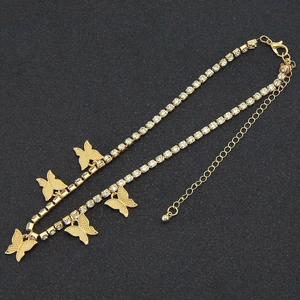 Détail de chaîne dorée avec cinq pendentifs papillon et strass brillants avec fermoir