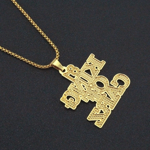 Primer plano del colgante hip hop dorado con letras KING y cadena box sobre fondo negro