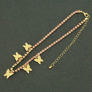 Détail d'un collier doré avec strass roses et cinq pendentifs de papillons