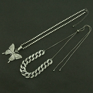 Détail du collier avec pendentif papillon et chaîne cubaine sertie de strass