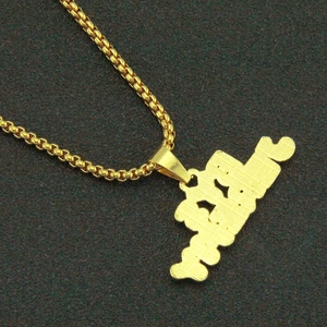 Macro detail of gold-tone ball chain and rectangular plaque pendant with crystal inlay