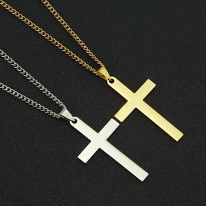 Colliers croix en acier inoxydable poli or et argent sur un fond en tissu noir texturé