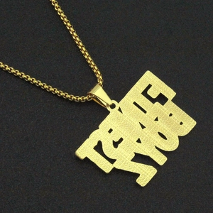 Nahaufnahme des goldenen LOVE YOU Anhängers mit strukturierter Oberfläche und Perlenkette