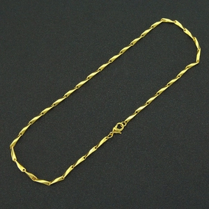 Detailed shot of golden twist link chain necklace featuring a secure lobster clasp closure
