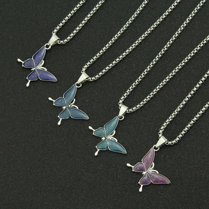Detailed view of four thermochromic butterfly pendant necklaces on beaded steel chains