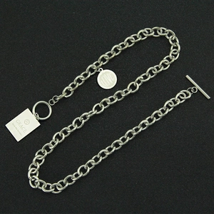 Détail du collier en acier inoxydable avec fermoir OT et breloques en métal gravé