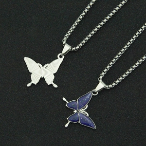 Detailed close-up of butterfly pendant necklace with blue glitter finish and steel box chain