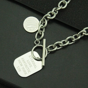 Détail de collier en acier inoxydable avec pendentif carré gravé et fermoir à bascule