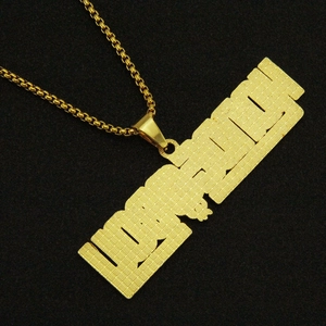 Vista macro del pendente dorato con scritta LOYALTY su catena box per stile hip hop
