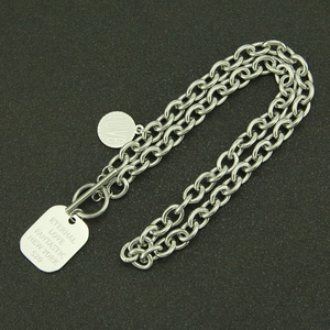 Détail du collier chaîne en acier titane argenté avec plaque carrée et fermoir à bascule