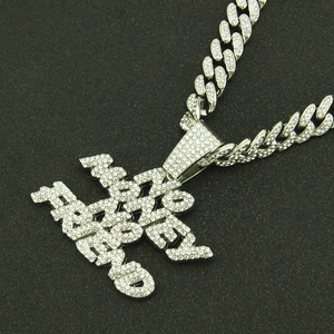Detail of silver Cuban link chain with iced-out Money Addict letter pendant necklace