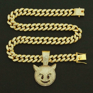 Détail du collier chaîne cubaine dorée avec pendentif monstre serti de strass brillants