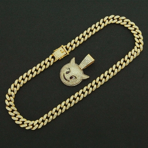 Détail macro d'une chaîne cubaine dorée et d'un pendentif emoji diable serti de strass