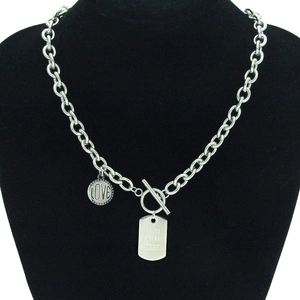 Détail du collier à chaîne argentée avec fermoir OT et pendentifs métalliques gravés