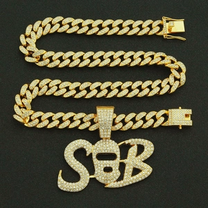 Hip hop gold Cuban link necklace featuring iced-out SB letters and masked figure pendant