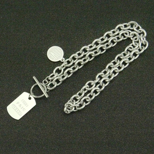 Détail d'une chaîne en acier inoxydable avec boucle OT et pendentifs gravés