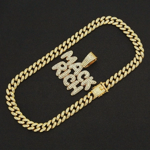 Vue détaillée du pendentif MACK RICH serti de strass sur une chaîne cubaine dorée