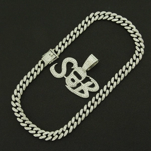 Close-up of iced-out silver Cuban link chain with SB letter pendant and crystal pavé