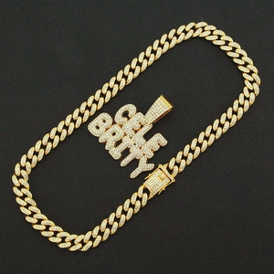 Macro detail of iced-out gold Cuban chain with thick CELEBRITY letter pendant