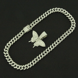Détail du pendentif papillon serti de pierres sur une grosse chaîne cubaine hip-hop