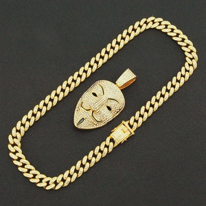 Détail du pendentif masque Guy Fawkes incrusté de diamants et chaîne cubaine dorée
