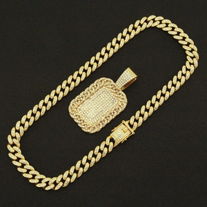 Detailed view of hip hop dog tag pendant and cuban link chain with sparkling crystals
