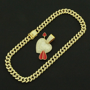 Détail du pendentif cœur avec flèche style hip-hop et chaîne à mailles cubaines dorées