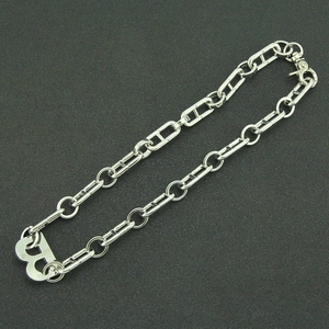 Macro shot of silver B-pendant necklace with H-shaped interlocking metal chain links