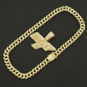 Détail de la chaîne cubaine dorée et pendentif DEWY serti de strass brillants