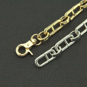 Detailed macro view of gold and silver anchor chain links with lobster clasps