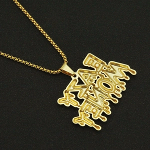 Détail d'une chaîne box dorée avec un grand pendentif alphabet de style fondant